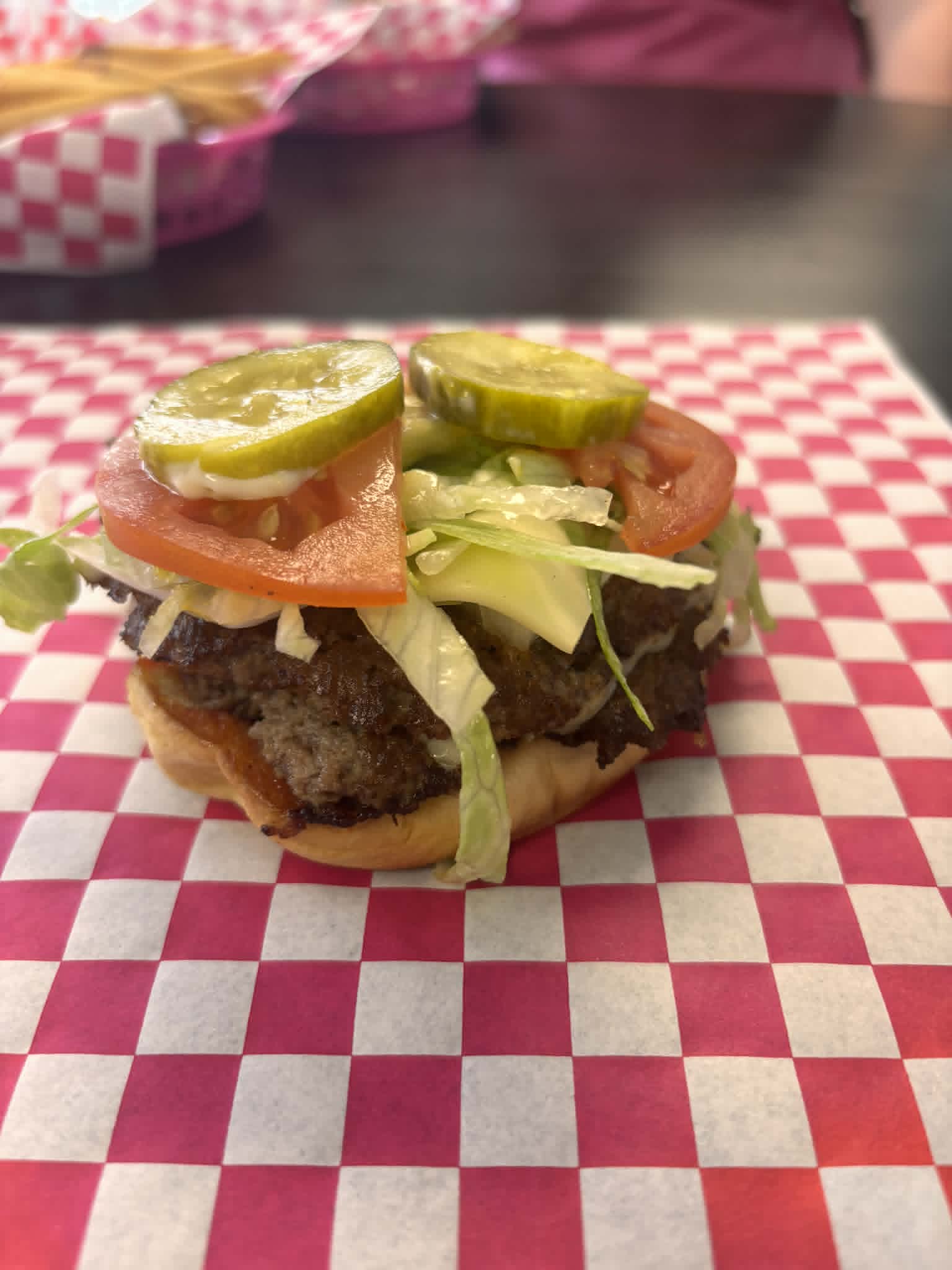 Loaded smash burger with lettuce, tomato, and pickles