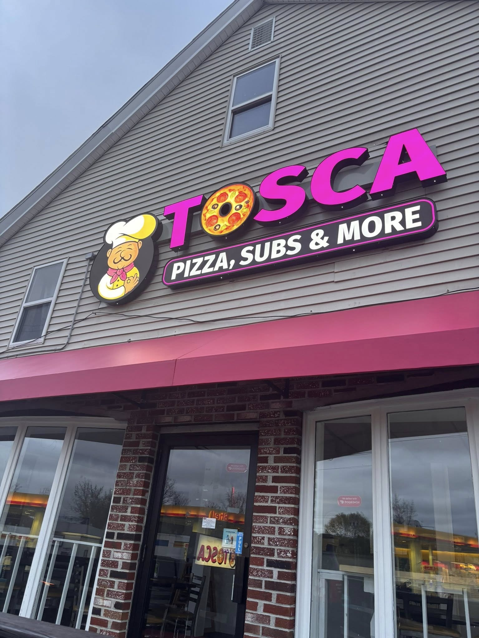 Tosca Pizza storefront with signature pink sign